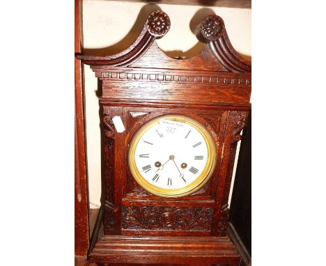 Victorian carved oak mantle clock with swan necked pediment having French movement striking on a gong, 15" tall