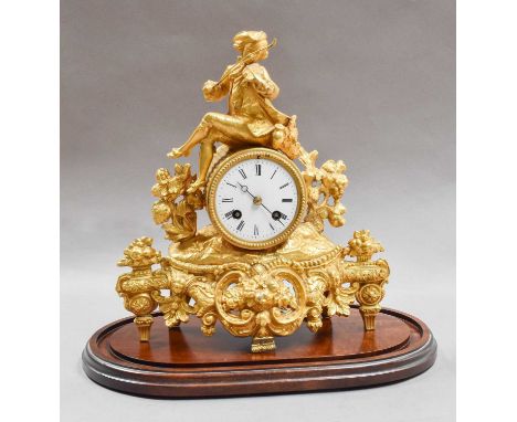 A Victorian gilt metal striking mantel clock beneath a glass dome, clock 29cm high
