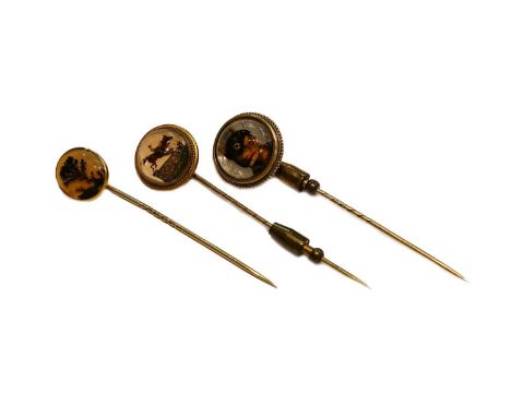 Two rock crystal reverse intaglio stickpins; and a moss agate stickpinThe dog example is in poor condition with fractures and