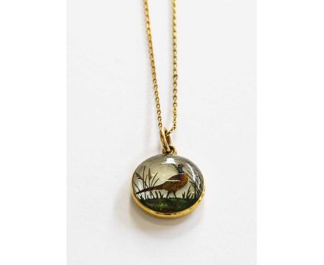 A rock crystal reverse intaglio pendant/Essex crystal, painted to depict a pheasant amongst foliage, on a trace link chain, p