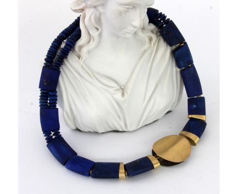 DESIGNERCOLLIER AUS LAPISLAZULImit Zwischengliedern aus 585/000 Gelbgold. Mittig vergoldete Metallscheibe mit geätztem Dekor.