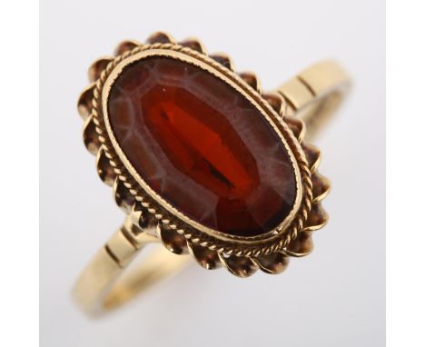 A 9ct gold garnet dress ring, set with oval step-cut garnet within rope twist surround, setting height 15.9mm, size O, 2.6gNo