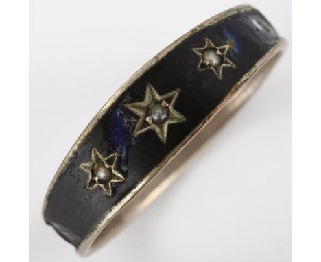 A Victorian pearl memorial ring, unmarked white metal settings with black enamel decoration and star motif, setting height 5.