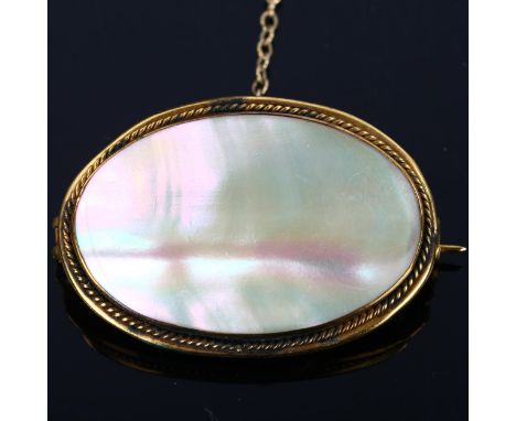A Victorian oval mother-of-pearl panel brooch, unmarked yellow metal settings with rope twist surround, brooch length 35.6mm,