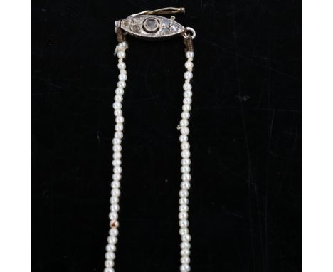 A fine graduated single-strand seed pearl necklace, with unmarked white metal diamond set clasp, pearls measure from 1.3mm to