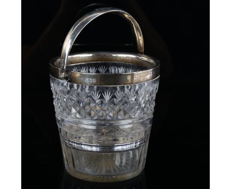 A George V silver-mounted glass ice bucket, with swing handle and pierced liner, armorial crest on handle, depicting knight w