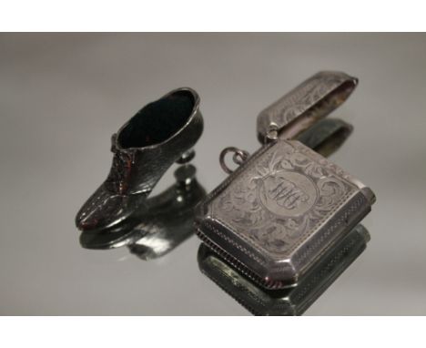 A HALLMARKED SILVER ENGRAVED VESTA CASE, TOGETHER WITH A NOVELTY SHOE SHAPED PIN CUSHION (2) 