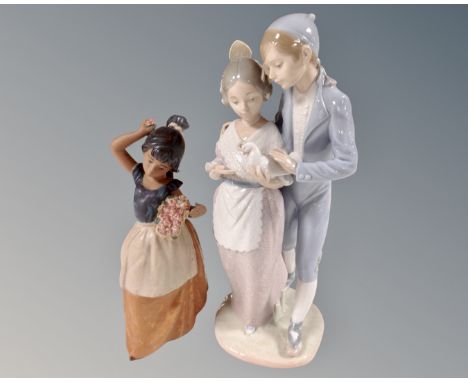 A Nao figure group of a boy and girl in Spanish dress holding a dove, a further Nao figure of a girl with flower basket in ma