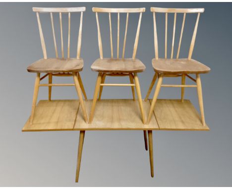 A set of three Ercol elm and beech spindle back dining chairs together with a further mid-20th century flap sided coffee tabl