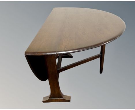 An Ercol solid elm and beech narrow drop leaf table (width 22cm) together with a set of six elm and beech Fleur de Lys dining