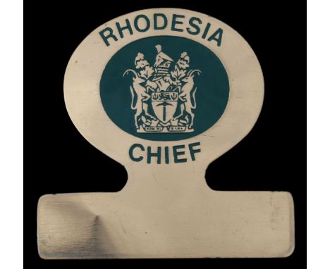 A Rhodesian Chief's Badge of OfficeBrass plate with lettering 'RHODESIA CHIEF' surrounding the Arms in green enamel, 76mm x 7