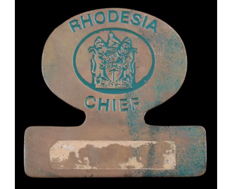 A Rhodesian Chief's Badge of OfficeBrass plate with lettering 'RHODESIA CHIEF' surrounding the Arms in green enamel, 76mm x 7