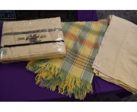 Three vintage wool blankets including one in original packaging and green and yellow checked blanket.