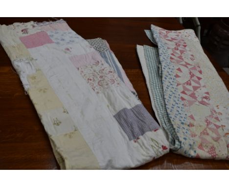 A large vintage quilt using a variety of cotton sections in various colours and patterns, some wear.