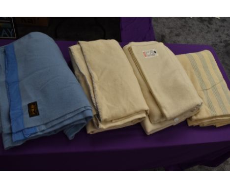 A collection of vintage wool blankets including blue blanket and CC41 labelled utility blanket.