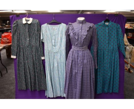 A collection of vintage and retro Laura Ashley dresses in a mixture of colours and styles.