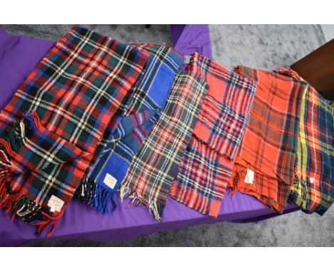 Seven vintage tartan travel rugs, one still having tags and original receipt.very good condition.