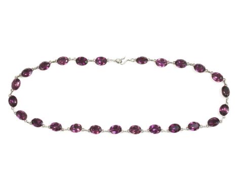 A Georgian silver and purple paste set rivière, c.1800-1820,with a series of oval mixed cut purple paste, each one rub set in
