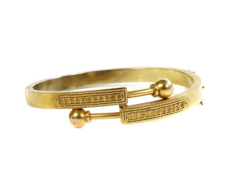 A Victorian gold, Archaeological Revival, Etruscan-style crossover hinged bangle, c.1870, a flat section bangle with crossove