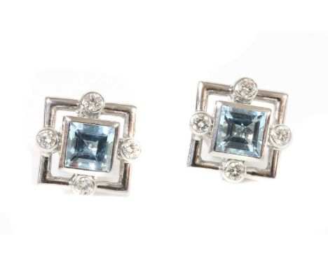 A pair of 18ct white gold aquamarine diamond stud earrings, c.2000,by Cassandra Goad. A square step cut aquamarine, rub set i