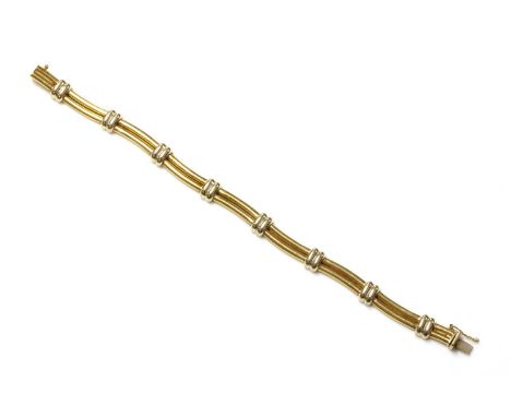 An Italian two colour gold wavy link bracelet,with pairs of 'D' section waved bars between pairs of white bridge links, to a 