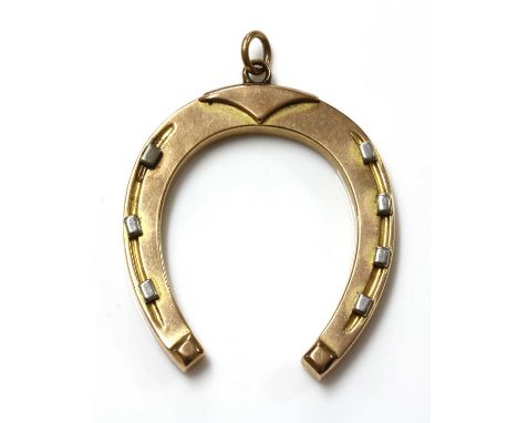 An Edwardian gold horseshoe fob or pendant,with a raised toe cover and heel, with platinum faced nail heads. Marked 15. 41 x 