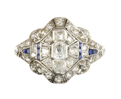 An Art Deco diamond and synthetic sapphire plaque ring, c.1930,possibly American. Three graduated emerald cut diamonds, milli