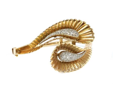 A French two colour gold diamond set crossover hinged bangle, c.1940,two crossover pear-shaped scrolls with white gold domed 