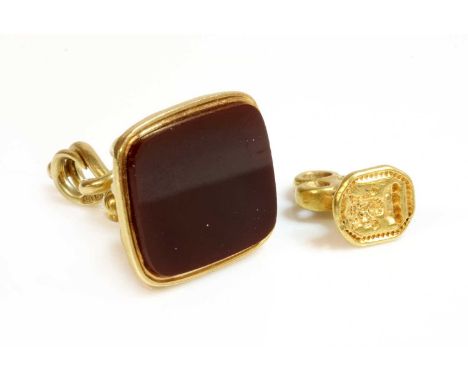 An 18ct gold twin snake or serpent cornelian seal,with two entwined snakes forming the back and bale, a cushion-shaped fluted