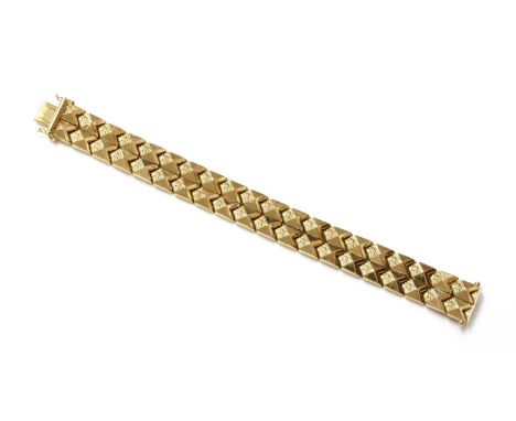 An Italian gold, two row chevron link bracelet, c.1960,with raised pyramid tops and repoussé flower head decoration. All back