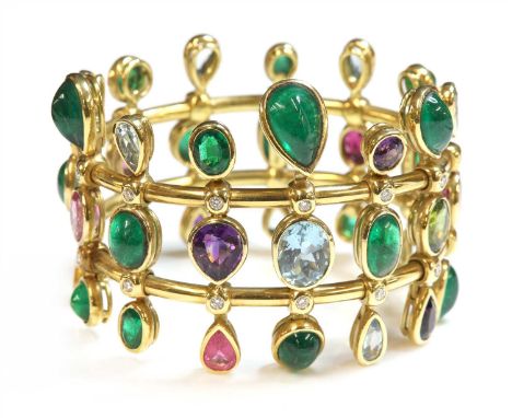 An 18ct gold emerald, aquamarine, amethyst, tourmaline, peridot and diamond hinged bangle, c.2000,by Julian Boles. Oval hinge