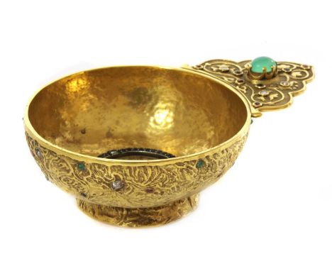 A gem set gold kovsh,of circular dish form with a flat scalloped handle and raised foot. An oval cabochon chrysoprase, claw s