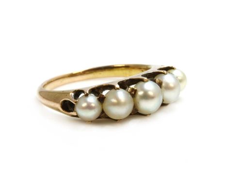 An Edwardian gold five stone pearl ring,with five graduated pearls, all claw set to a scalloped gallery, plain shoulders and 