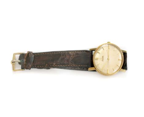 A gentlemen's 9ct gold Omega automatic strap watch, c.1963, with a 32mm case. A finely brushed champagne dial with raised gol