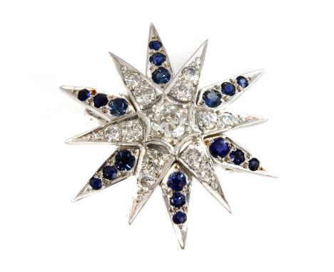 A white gold diamond and sapphire India Star brooch,with a brilliant cut diamond, grain set to the centre radiating tapered r