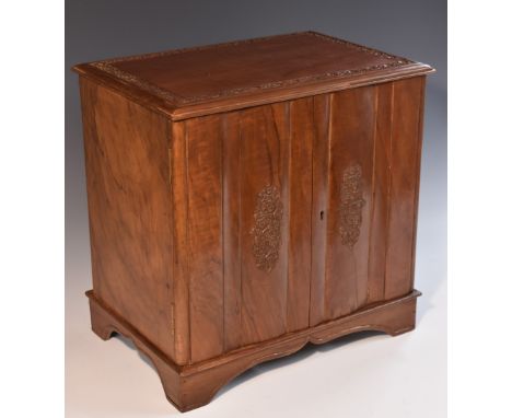 An Indian hardwood table cabinet, rectabngular top above a pair of doors enclosing three drawers, carved with a border and re