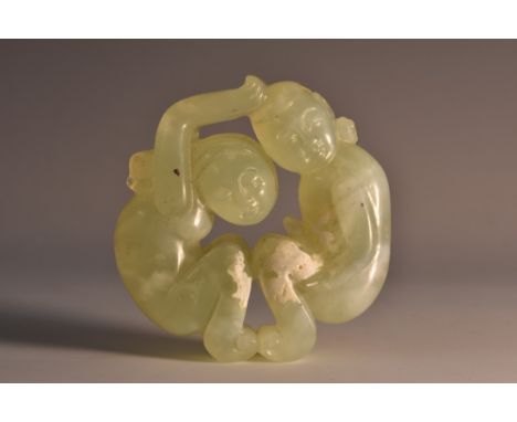 A Chinese pale green jade roundel, carved as an erotic subject, 6cm diam 