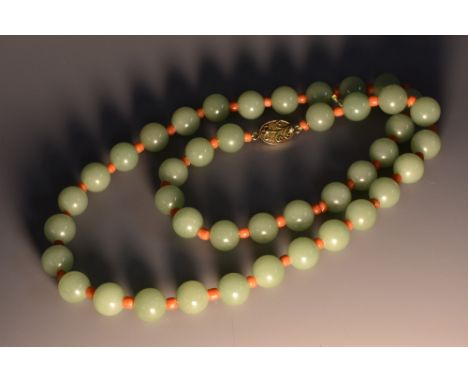 A Chinse jade necklace, the forty-two spherical beads divided by coral spaces, silver-gilt clasp, 31cm drop 
