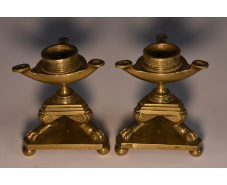 A pair of Regency brass candlesticks, in the Grecian Revival taste, oil lamp sconces, baluster supports terminating on a tier