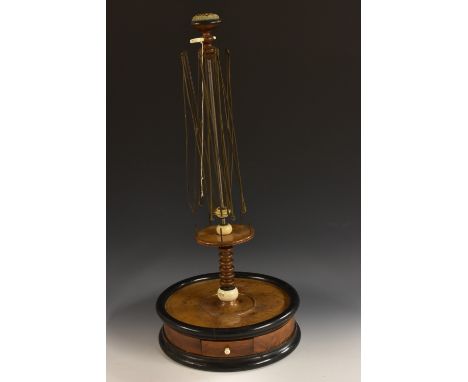 An early Victorian yew and ebonised tabletop woolwinder/seamstress's companion, pin cushion cresting above an expanding steel