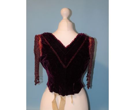 An early-Victorian plum-coloured velvet bodice, the neckline trimmed with faceted red glass beads, the sleeves a lattice of b