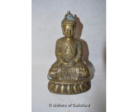 A Chinese bronze figure of a god seated on a lotus flower, 18.5cm.