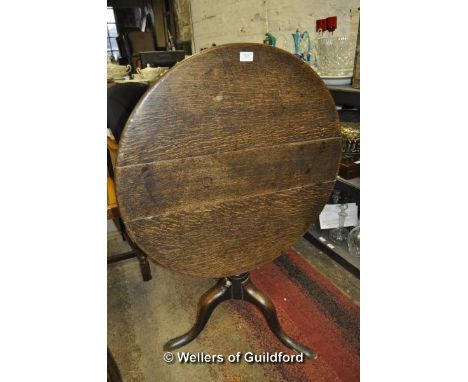 An oak circular tilt top tripod table, 74cm diameter; together with an oak oval gateleg dining table.