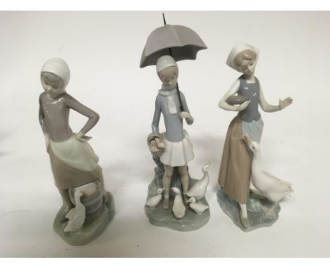 Three Lladro figures In the form of ladies one feeding a Goose one with a umbrella and one feeding a Duck. All appear to be i