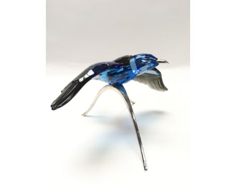 A swarovski diamond in the shape of a blue roller. Appears in excellent condition, with certificate and box.