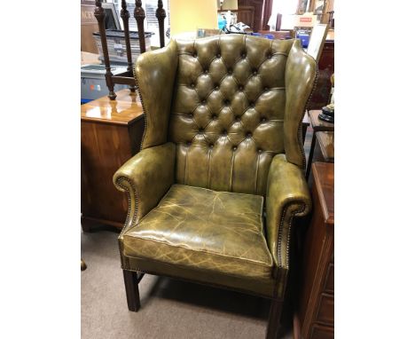 A Green leather and Mahogany wing arm chair with button back leather and a drop in cushion