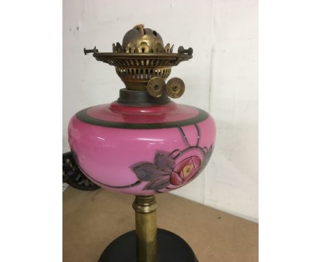 A oil lamp with pink font and cranberry shade .