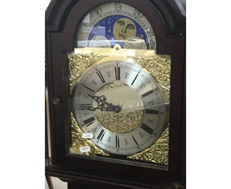 A reproduction mahogany longcase clock with visible pendulum and weights the dial with a moon roller.