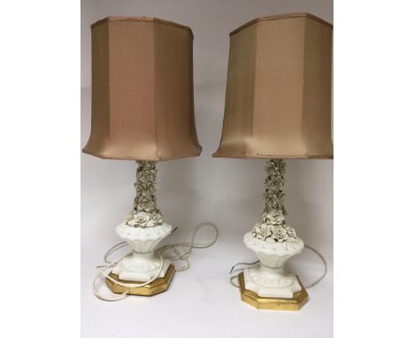 Two white glazed ceramic lamps encrusted with raised flowers on gilt wood bases. With shades hight 75cm