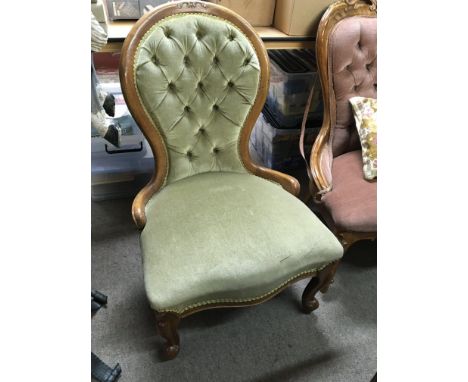 A Victorian Ladies chair with green draylon upholstery with a button back on cabriol legs.